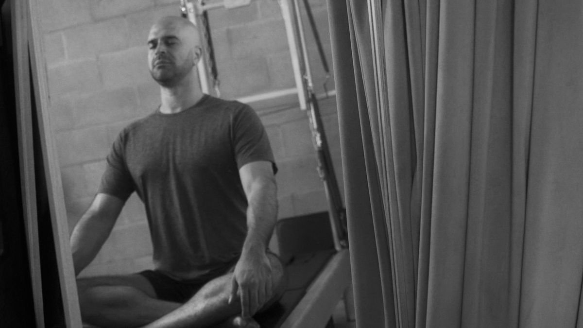 A peaceful Pilates studio in Los Angeles offering a sanctuary for holistic fitness, with a Pilates enthusiast engaging in mindful exercises on a Contrology Tower.
