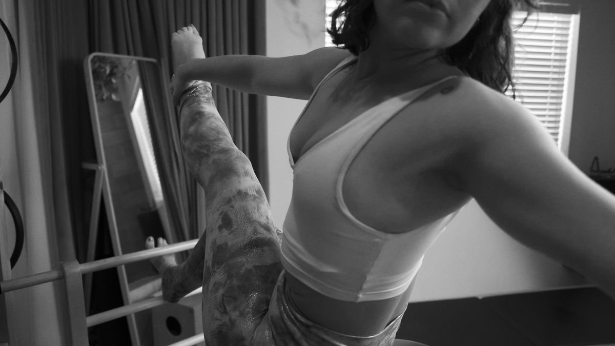 A person practicing Pilates in a home setting with a busy schedule, balancing work and personal life.