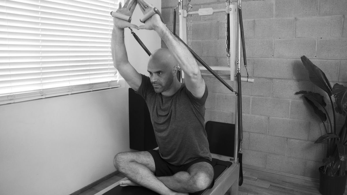 Image of a person doing a Pilates exercise with a focused and calm expression, symbolizing the strengthening of emotional resilience through Pilates practice.
