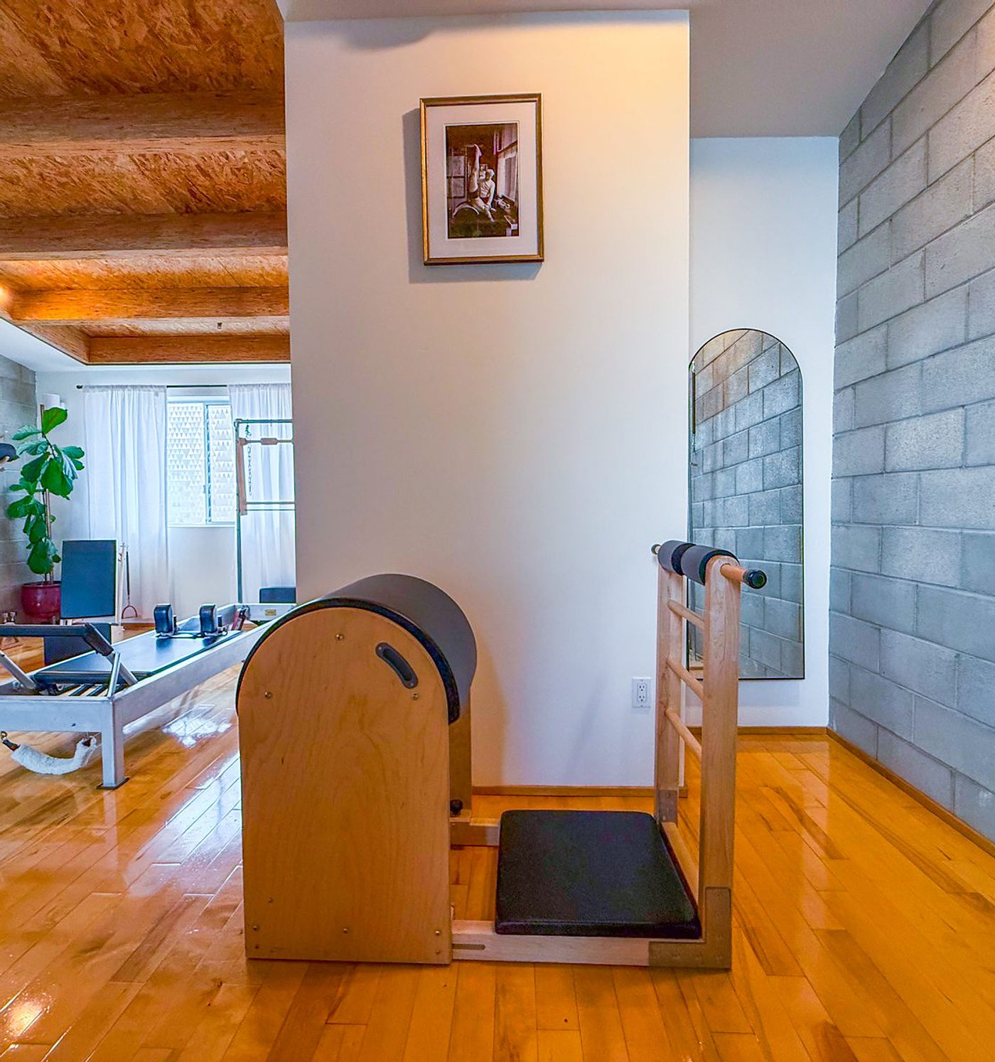 A wooden ladder barrel and spine corrector in the foreground, with a framed print behind